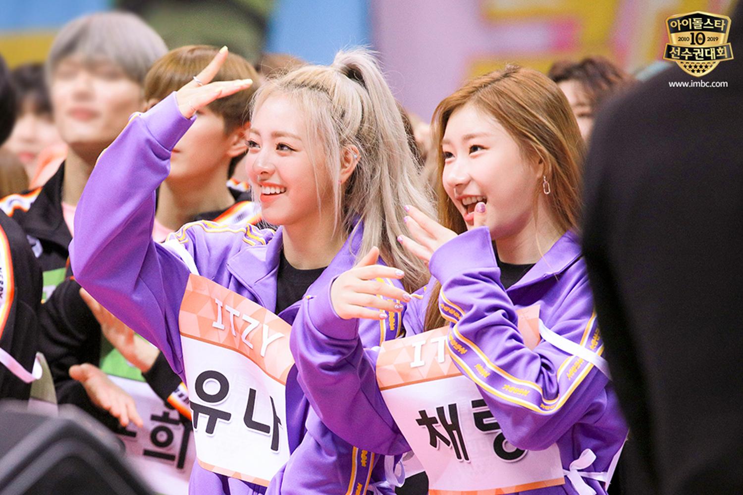 兩位穿著運動服的女性韓星在活動中互動,以擁抱和歡呼展示友誼和支持。