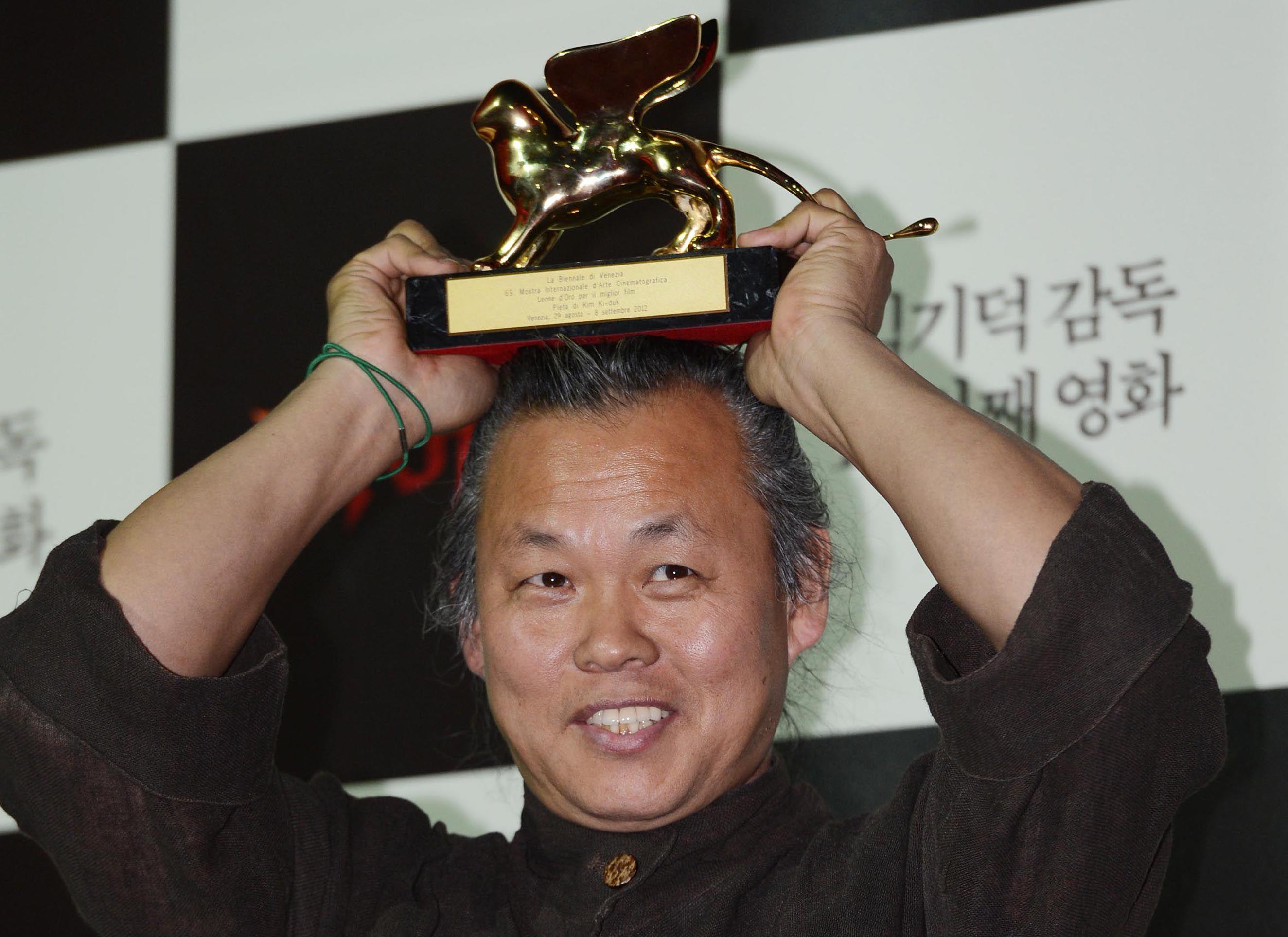 ベネチア国際映画祭で金獅子賞を受賞したトロフィーを掲げる場面。