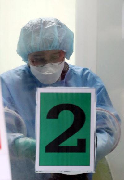 ソウル銅雀区保健所の選別診療所で検体採取を行う医療スタッフの様子。