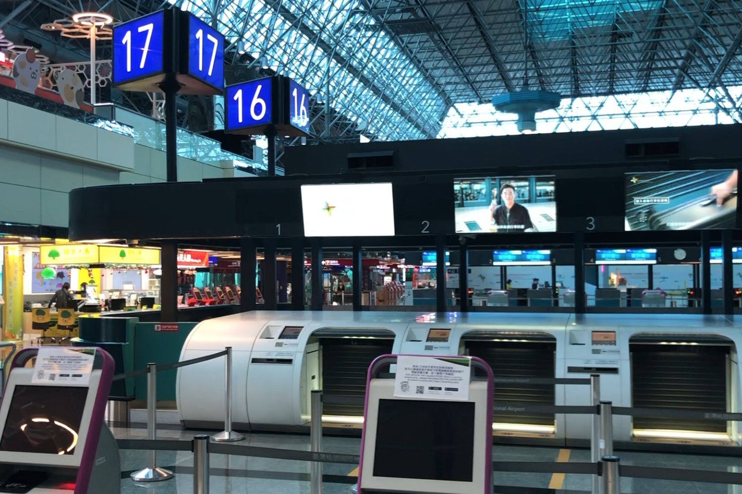 Mostradores de registro en un aeropuerto vacío numerados del 16 al 17, sin presencia de pasajeros.