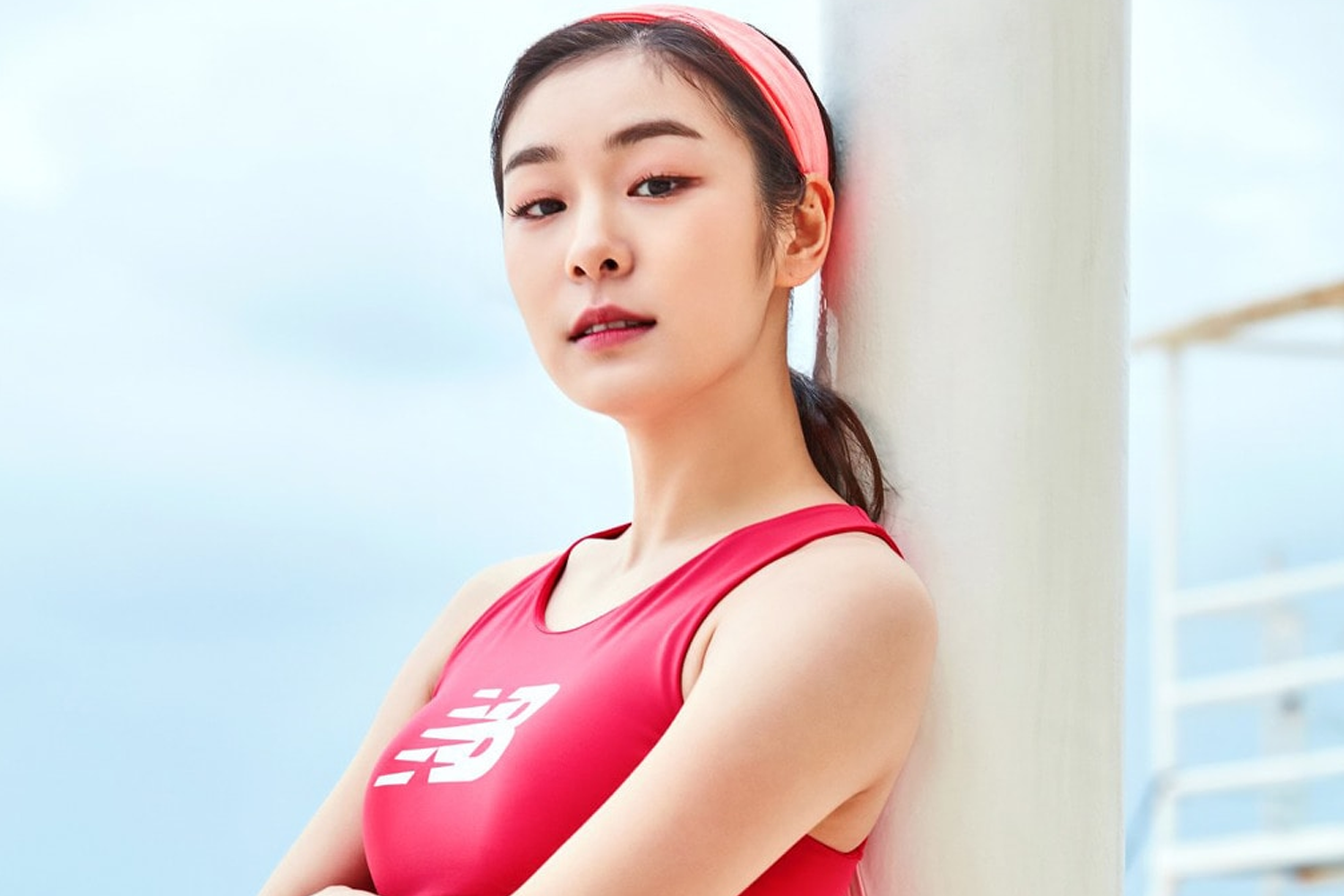 運動品牌形象廣告，模特身穿紅色運動背心，倚靠在柱子上。