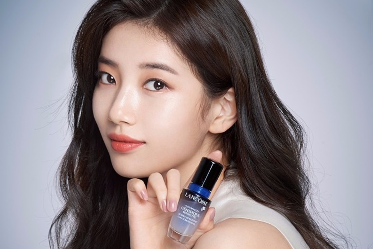 蘭蔻美容產品廣告，模特握著一瓶藍色和黑色相間的產品。
