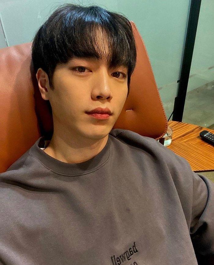 俳優ソ・ガンジュンがソファに座っており、厚手のブラウントレーナーを着てリラックスしている姿が見られる。