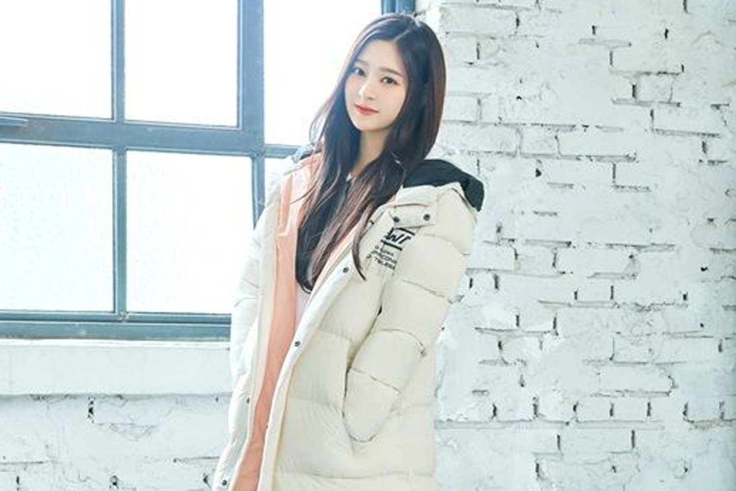 IZ*ONE出身的玟周穿著白色羽絨外套，站在白磚牆前