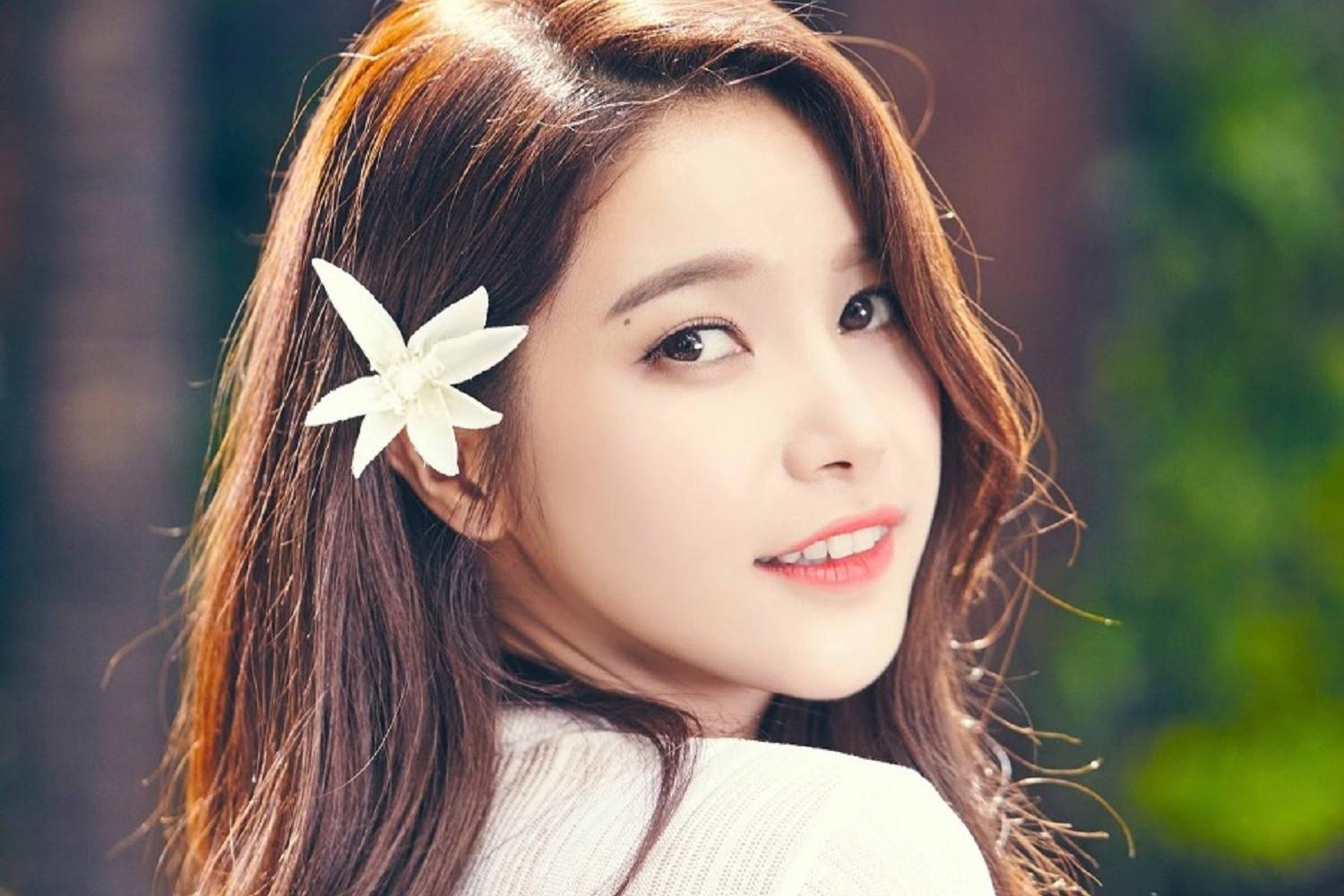 花飾りをつけた女性の後ろ姿。焦げ茶色の髪に白い花が印象的です。