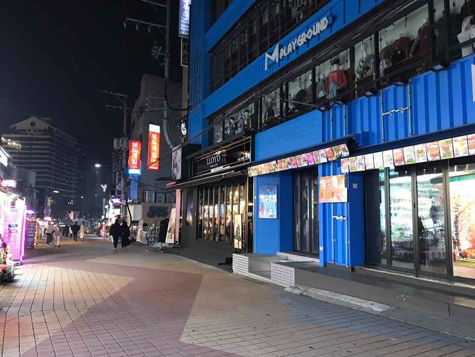 首尔弘大夜间购物街，七彩路面，店铺广告灯光明亮。