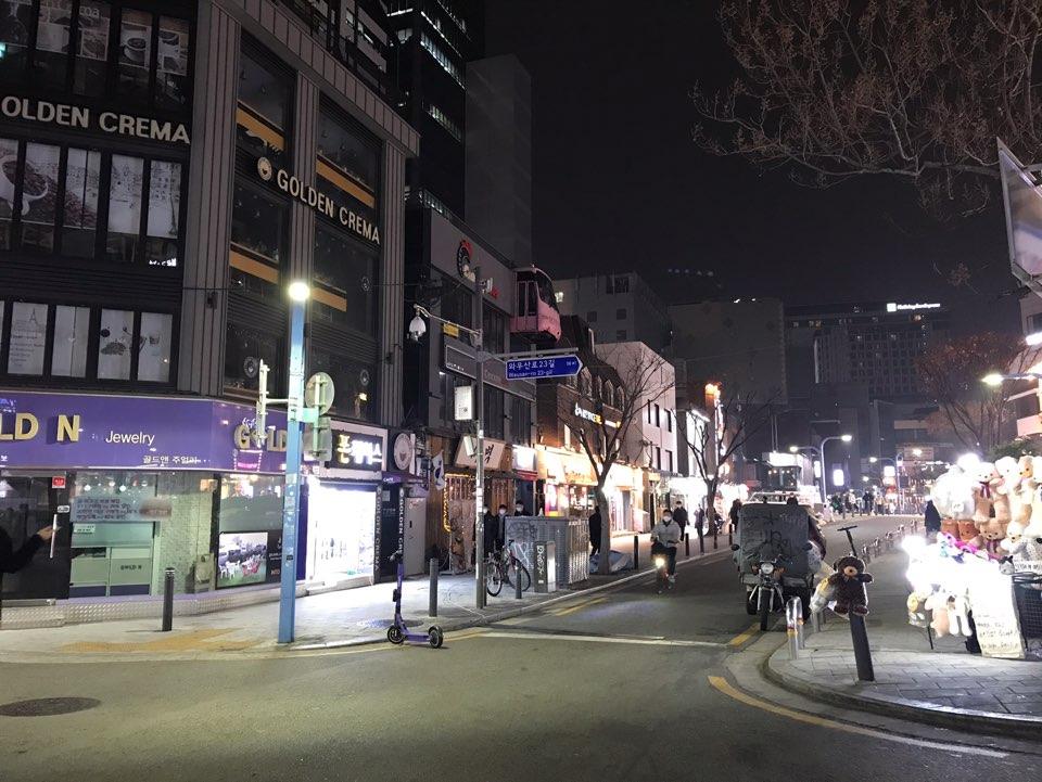 首尔弘大道口繁华地带，夜晚店铺灯火通明，行人寥寥无几。