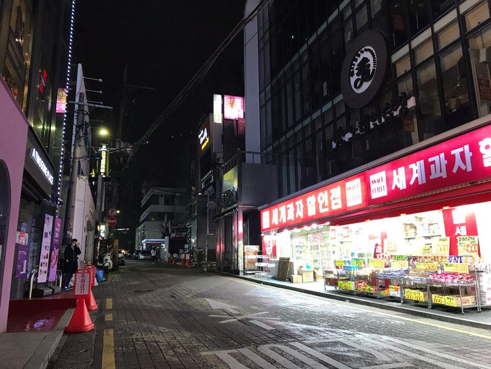 首尔弘大商业小巷夜景，店面关闭，街道安静，透露出疫情下的氛围。
