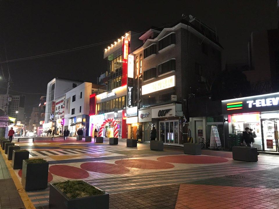 首尔弘大街区夜晚景观，店面灯光闪烁，街道显得尤为静寂。