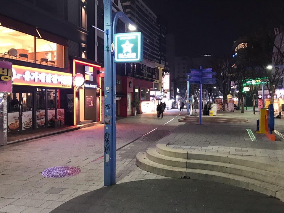 首尔弘大街头夜景，行走于九号出口附近的稀少人群。