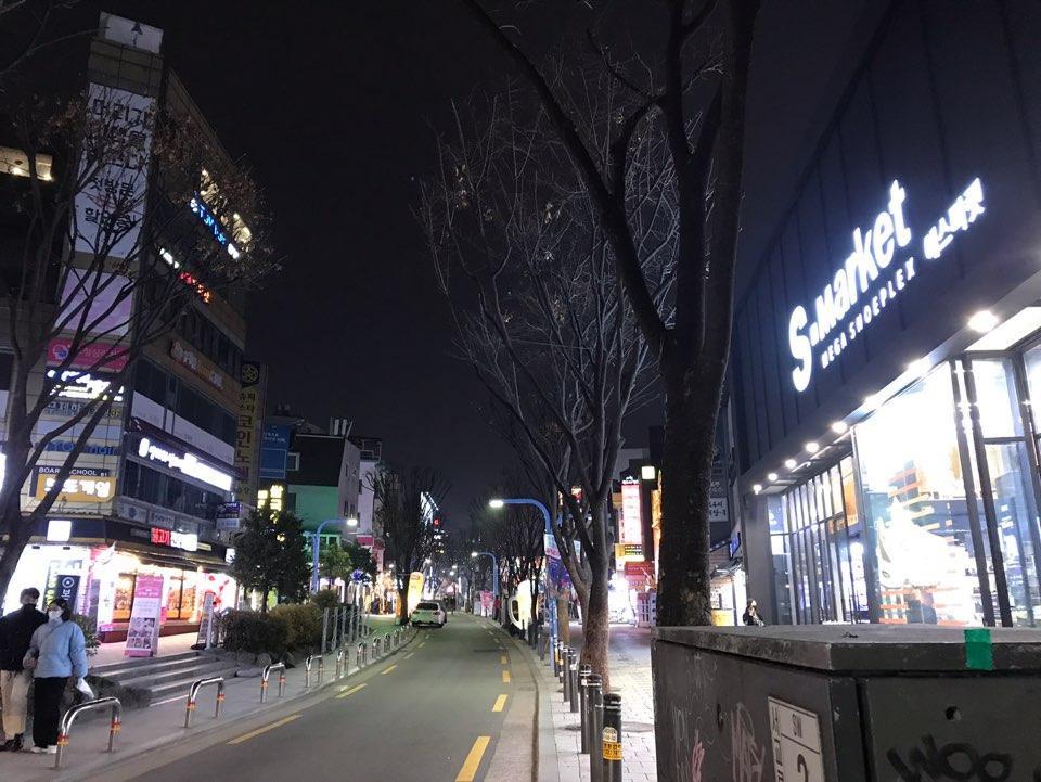 首尔弘大道两旁的夜景，店铺灯光明亮，街道显得非常静谧。