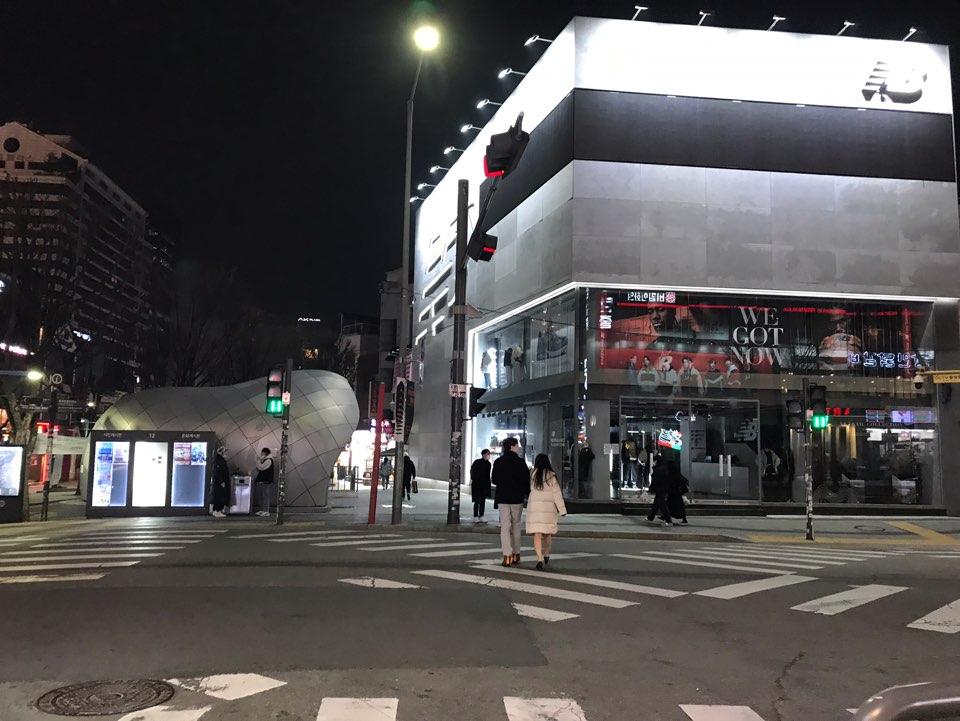 首尔弘大商店街空无一人的夜景，街边店铺灯火辉煌。