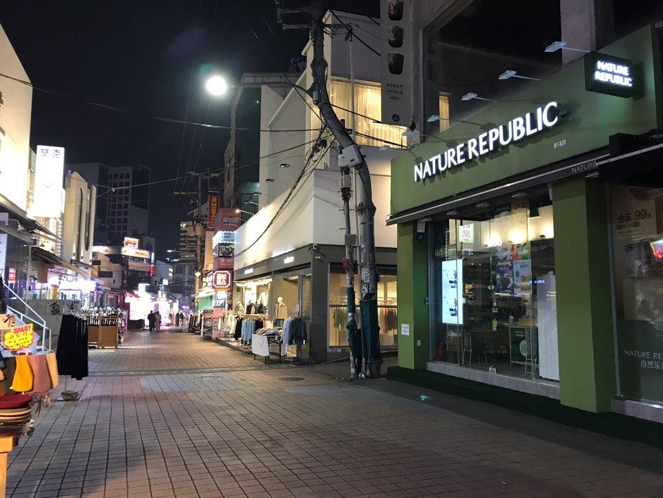 首尔弘大商圈，夜晚人流较少，街道两侧繁华的商店。