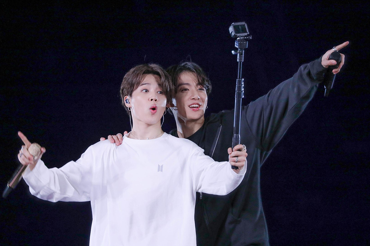 兩名人物在舞臺上進行表演，背景燈光昏暗，人物動作活潑