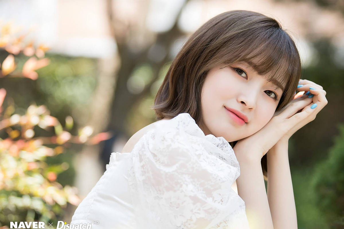 戶外自然背景下一位穿著白色上衣的女性，懶洋洋地側躺著享受午後的陽光