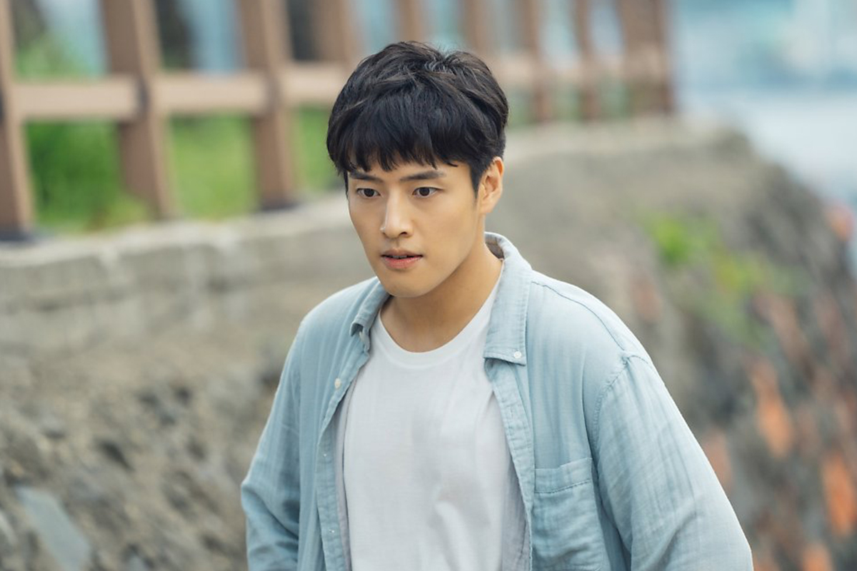 一名男性於戶外休閒步行，背景是釜山的自然景觀