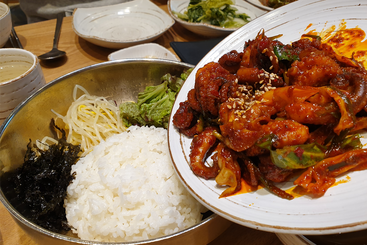 松鼠村鍋巴燉雞餐廳內拌飯和小章魚配菜的特寫照片