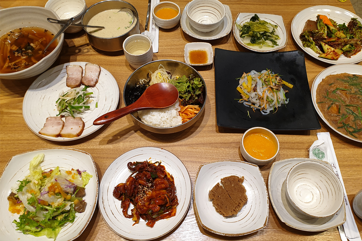 松鼠村鍋巴燉雞餐廳內的豐盛多道韓餐桌餐的照片