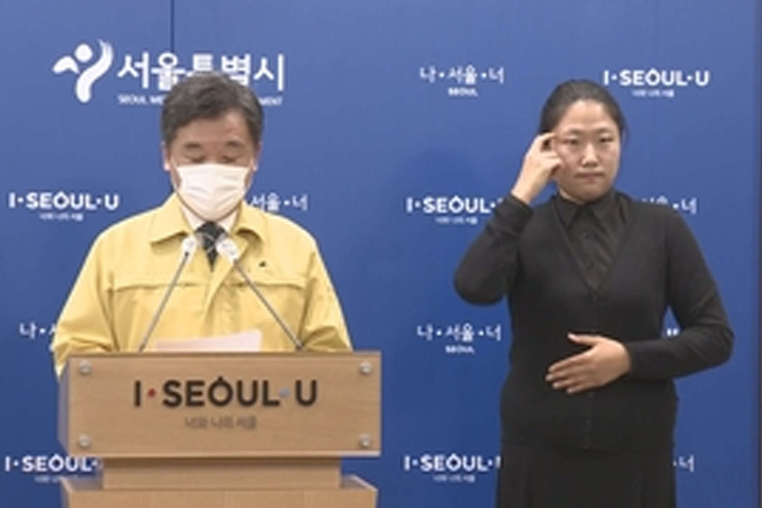 首爾市政府新聞發布會上與會者用手勢進行翻譯，宣佈5人限聚令實施細則。