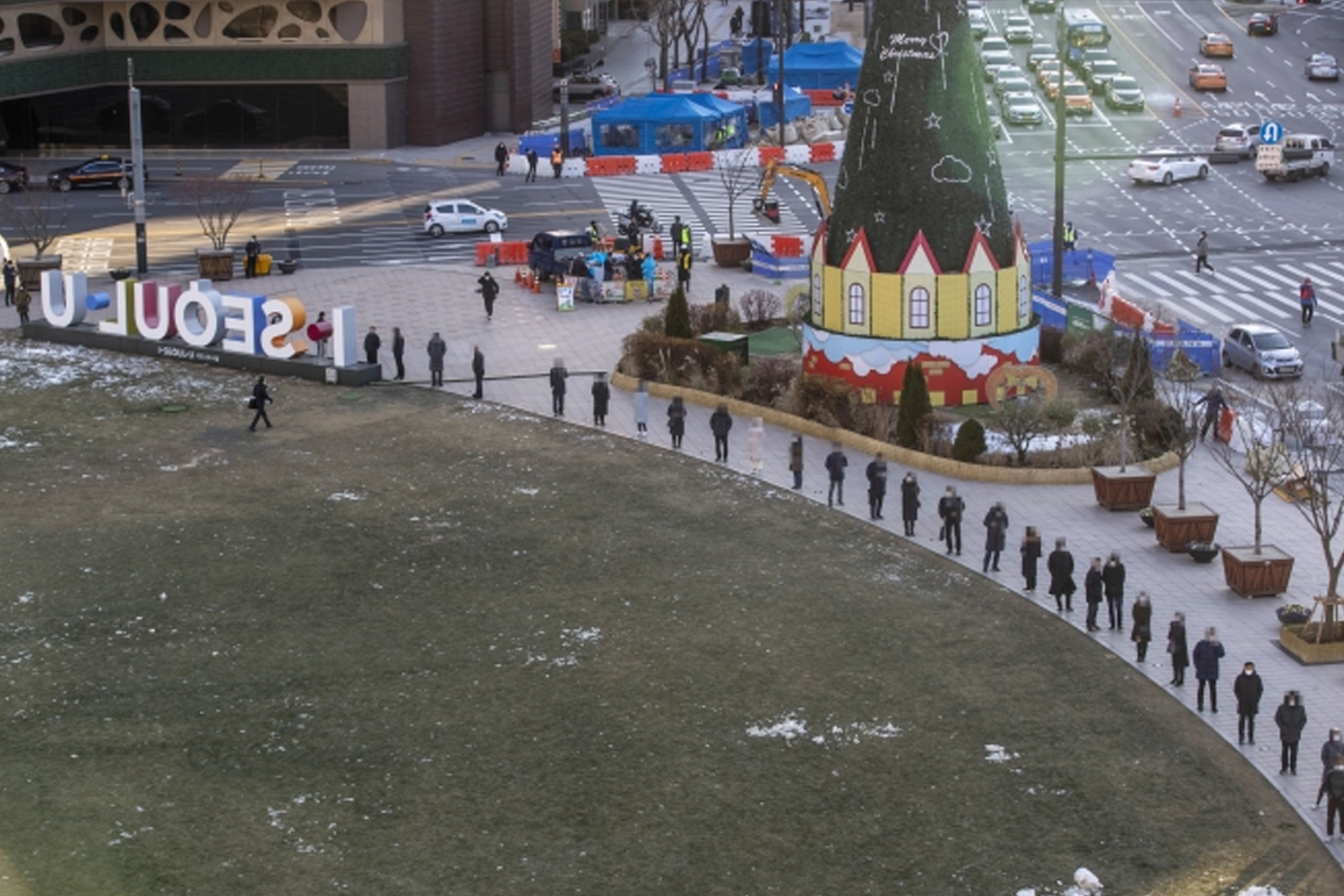 首爾市中心廣場上，市民們排隊保持社交距離，遵守5人限聚令。