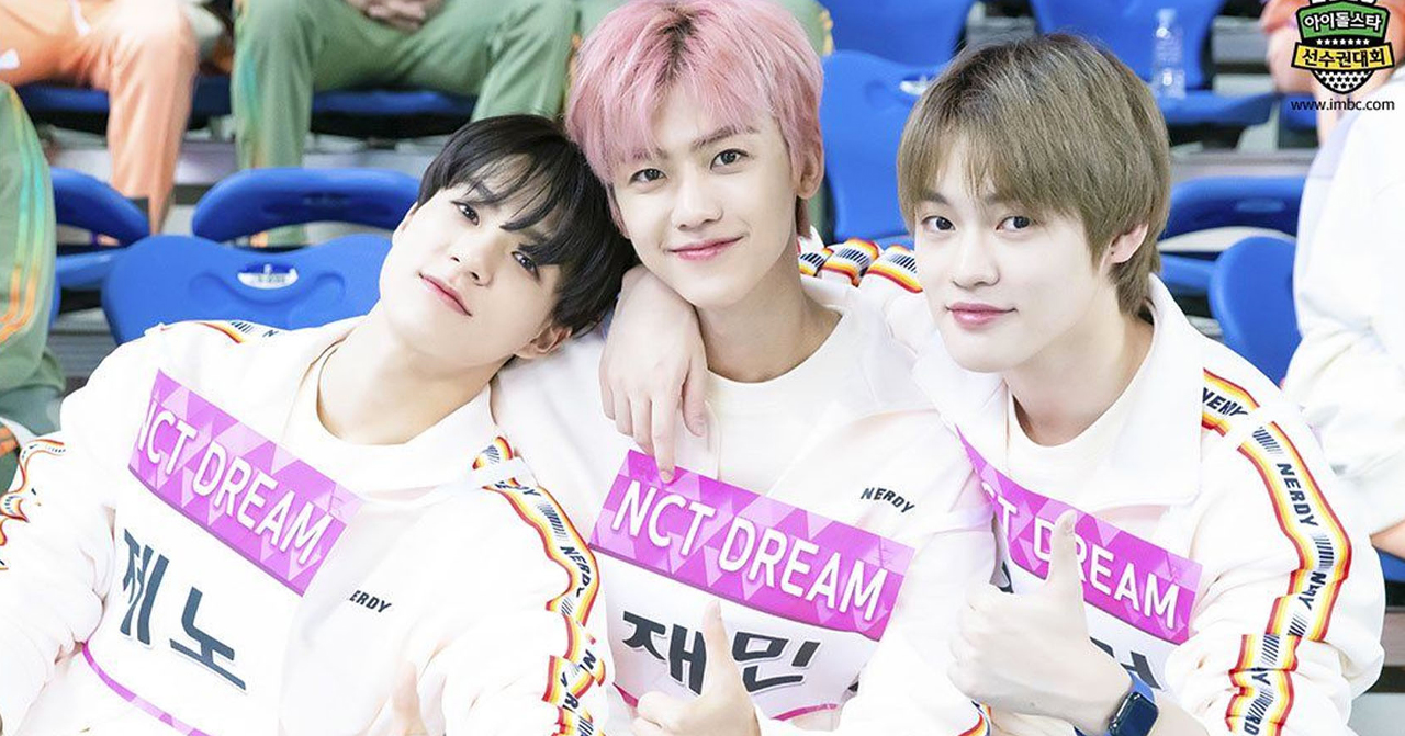 三位韓國偶像穿著白色運動服，背景為室內體育場。