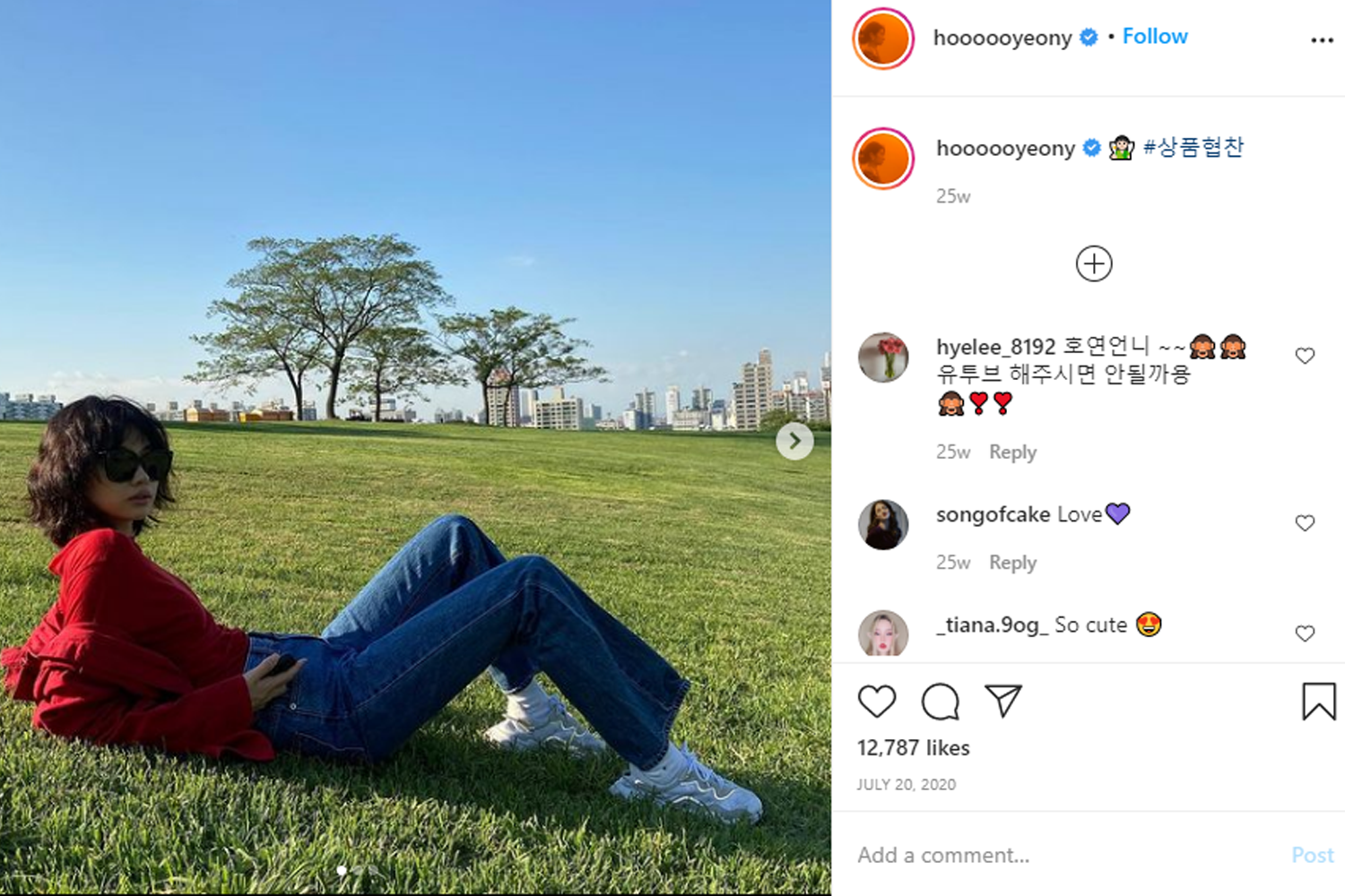 穿著紅色上衣和藍色牛仔褲，躺在公園草地上的韓國模特兒Jung HoYeon，傳遞簡約復古風格的韓系穿搭。