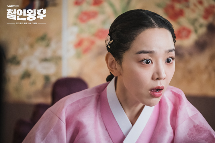 韓劇《哲仁王后》中的人物穿著華麗的衣服，背景中顯示出古樸的建築細節，營造出朝鮮時代的感覺。