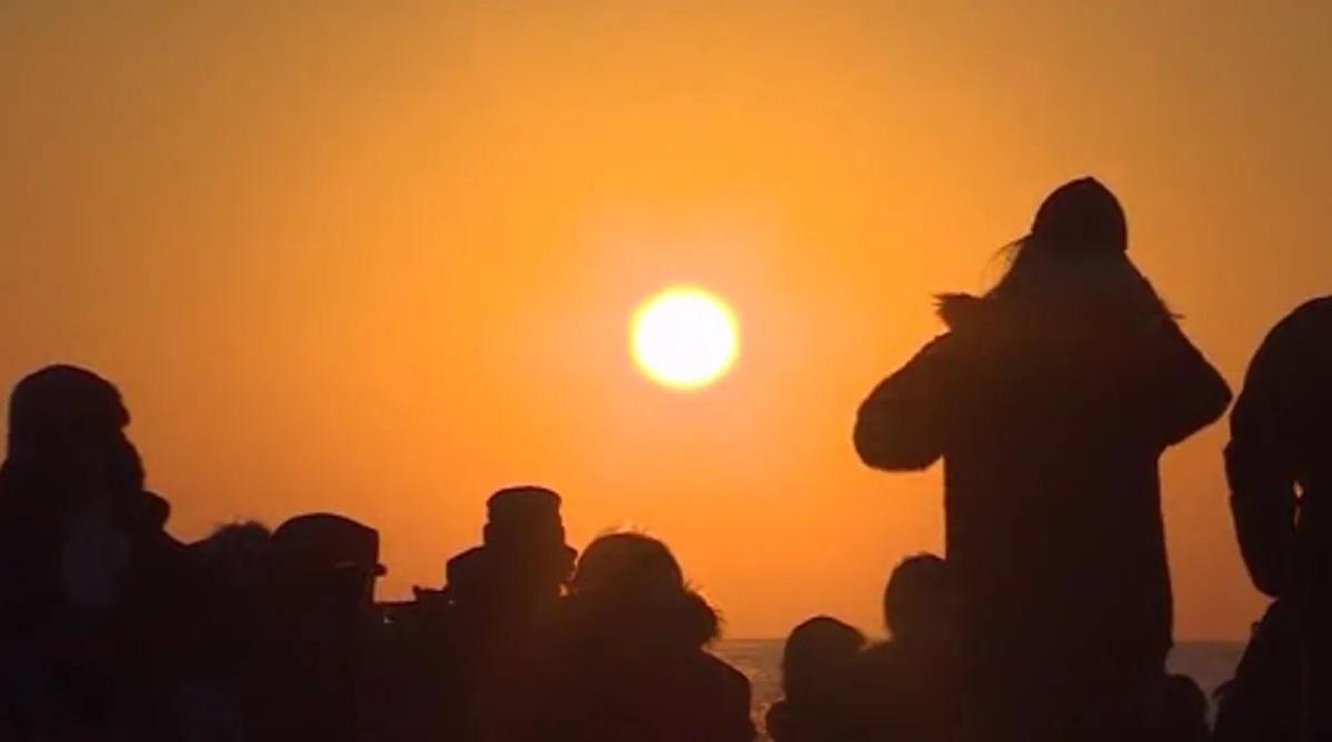 พระอาทิตย์ตกดินเหนือขอบฟ้าที่มีเงาของคนหลากหลายคน ซึ่งสะท้อนถึงช่วงเวลาพิเศษและเป็นธรรมชาติในประเทศไทย
