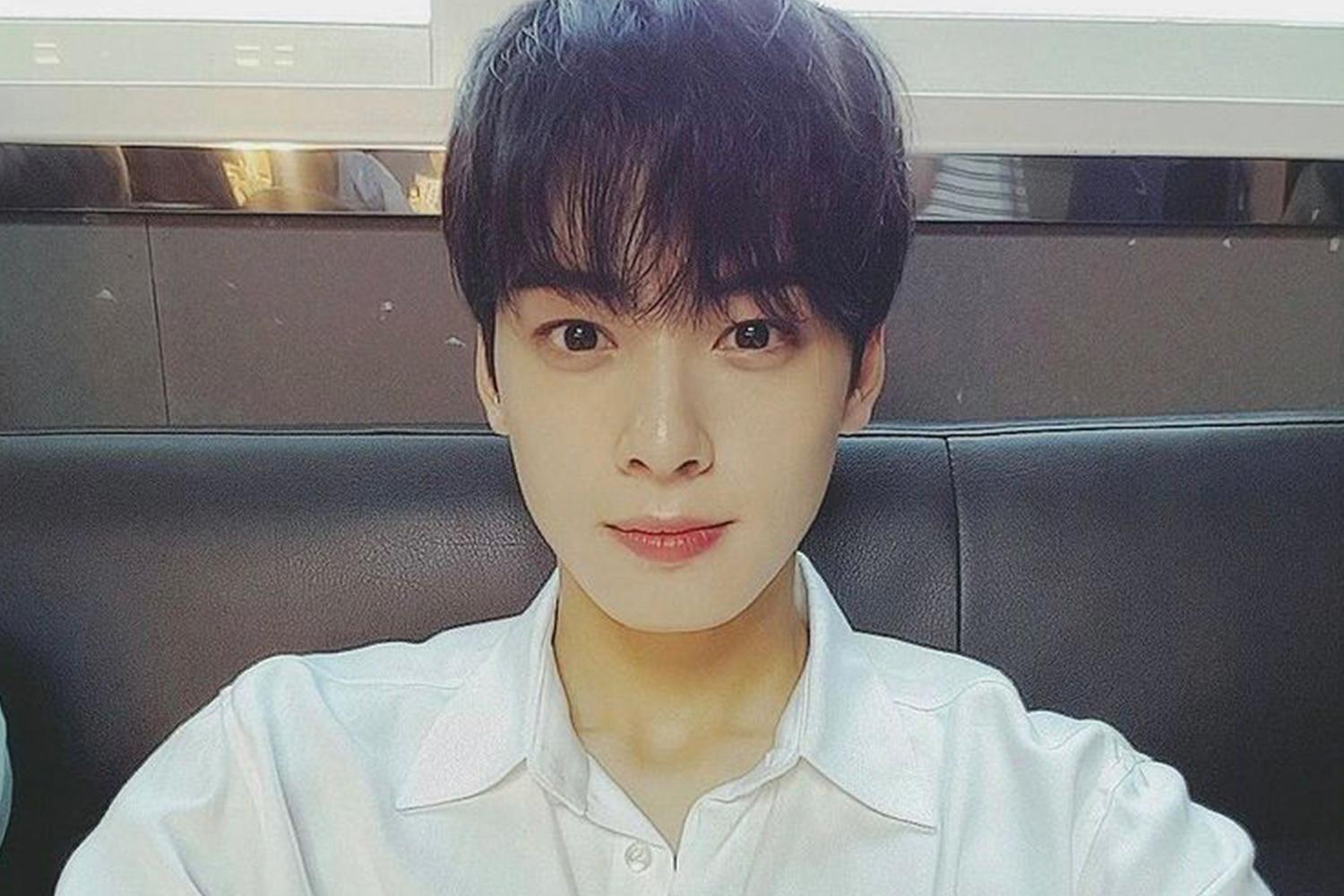 ASTRO 的成員車銀優坐在沙發上，身穿白色襯衫，背景是室內環境。