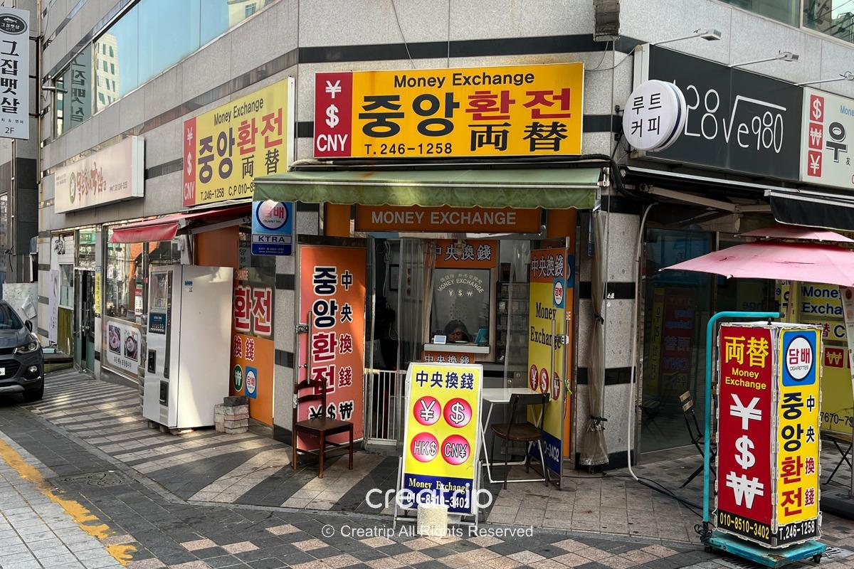 釜山中央換錢所的入口，標示提供各種貨幣的兌換服務，位於南浦洞繁華的市場區域。