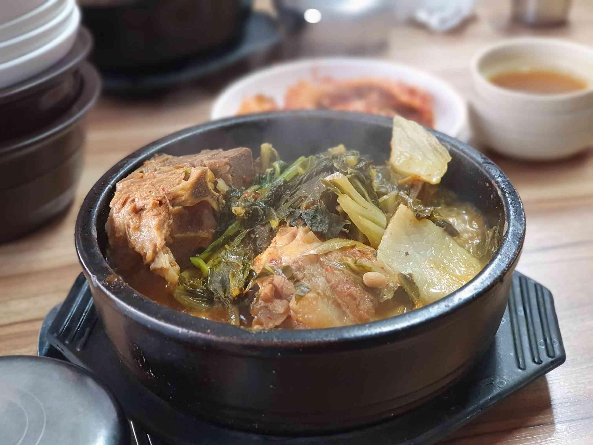 ซุปเกาหลีที่ปรุงด้วยซี่โครงหมูและผักสดในชามดินเผา, เหมาะสำหรับรักษาอาการเมาค้างในตอนเช้า