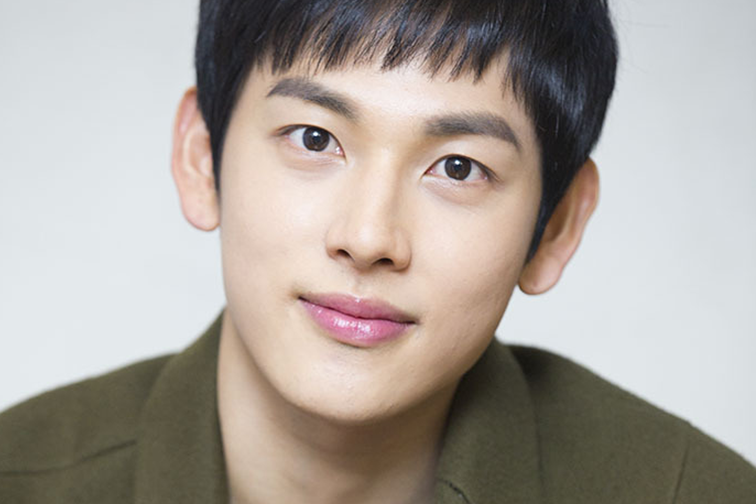 韓國藝人時完的學生時代形象，身著綠色外套，看起來非常沉穩。