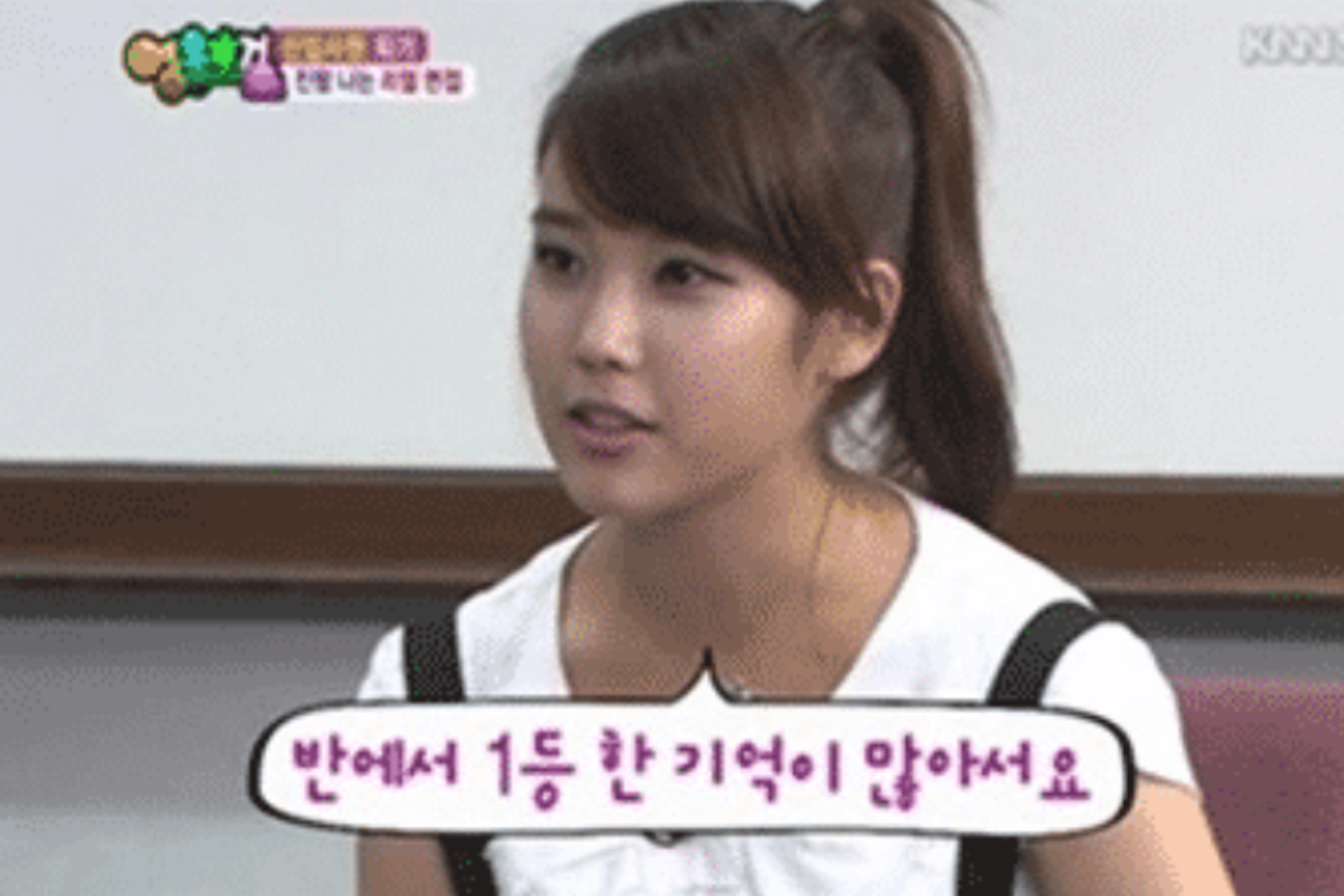 IU在小學一年級時期，坐在椅子上接受訪問，顯得非常謙遜。