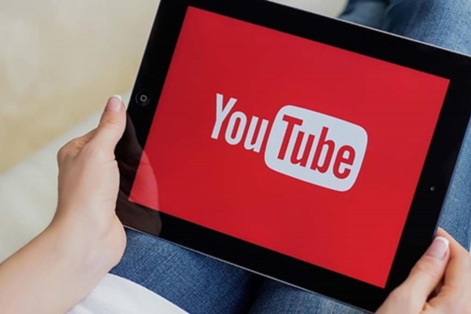 一個人使用平板電腦觀看YouTube主頁，反映居家娛樂和網上觀看影片的趨勢。