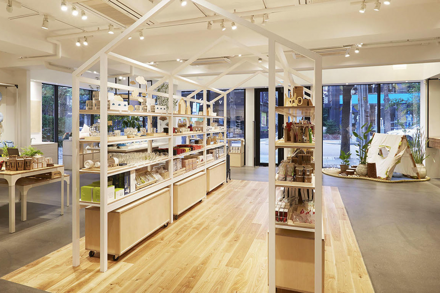 Interior de la tienda insignia de JAJU en Sinsadong, mostrando su exposición de productos organizados en estructuras únicas, con una estética minimalista y acogedora.