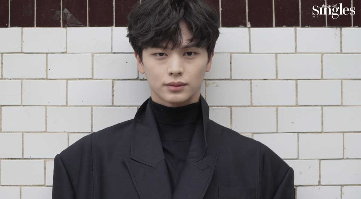 韓國男子組合BTOB的成員星材，身穿黑色西裝，背後有白磚牆作為背景，展現酷炫魅力