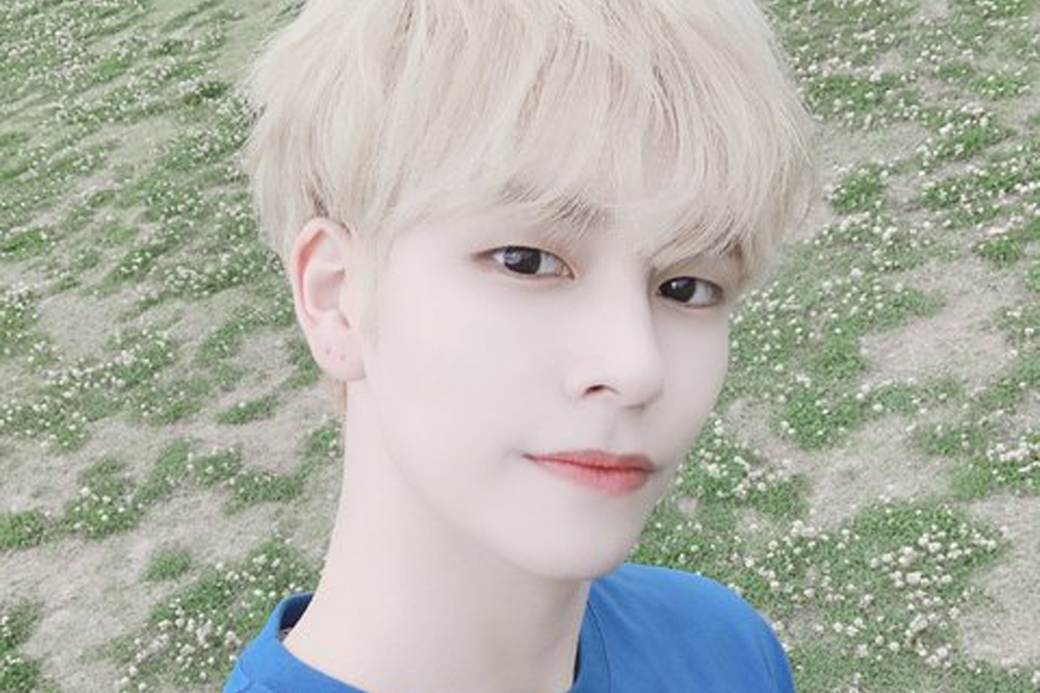 韓國男子組合CRAVITY的成員世琳，站在草地上，身穿藍色T-shirt，展現自然活力感