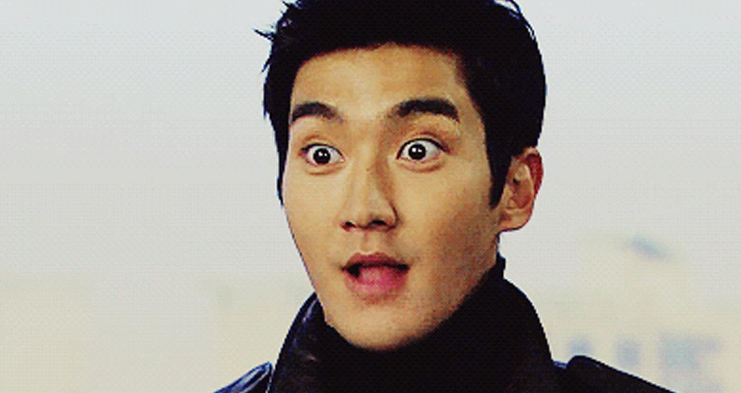 ชายที่ยืนสวมเสื้อโค้ทสีดำ มีบรรยากาศที่ดูสงบนิ่งและเคร่งขรึมในเกาหลี