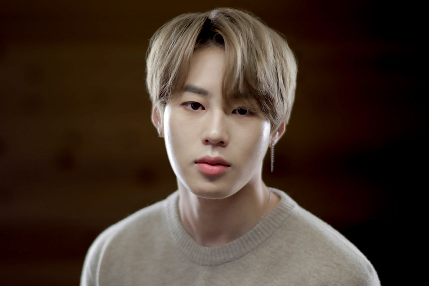 남성 배우가 우아한 검은 색 정장을 입고 과일을 든 모습.