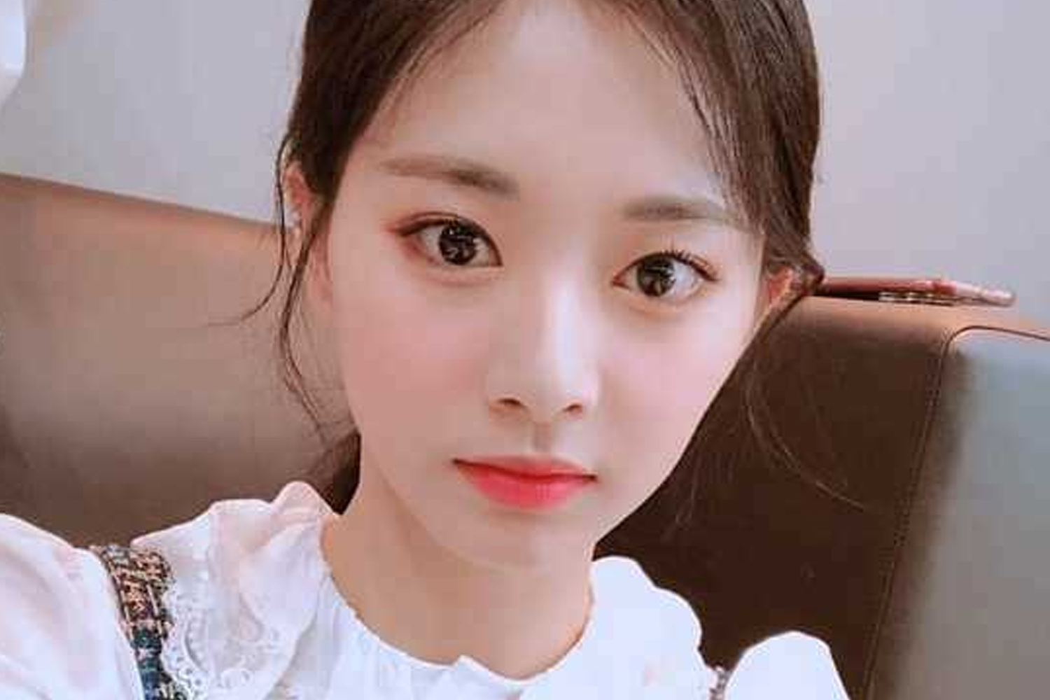 TWICE의 멤버 쯔위가 부드러운 소재의 흰색 블라우스를 착용하고 있는 모습.