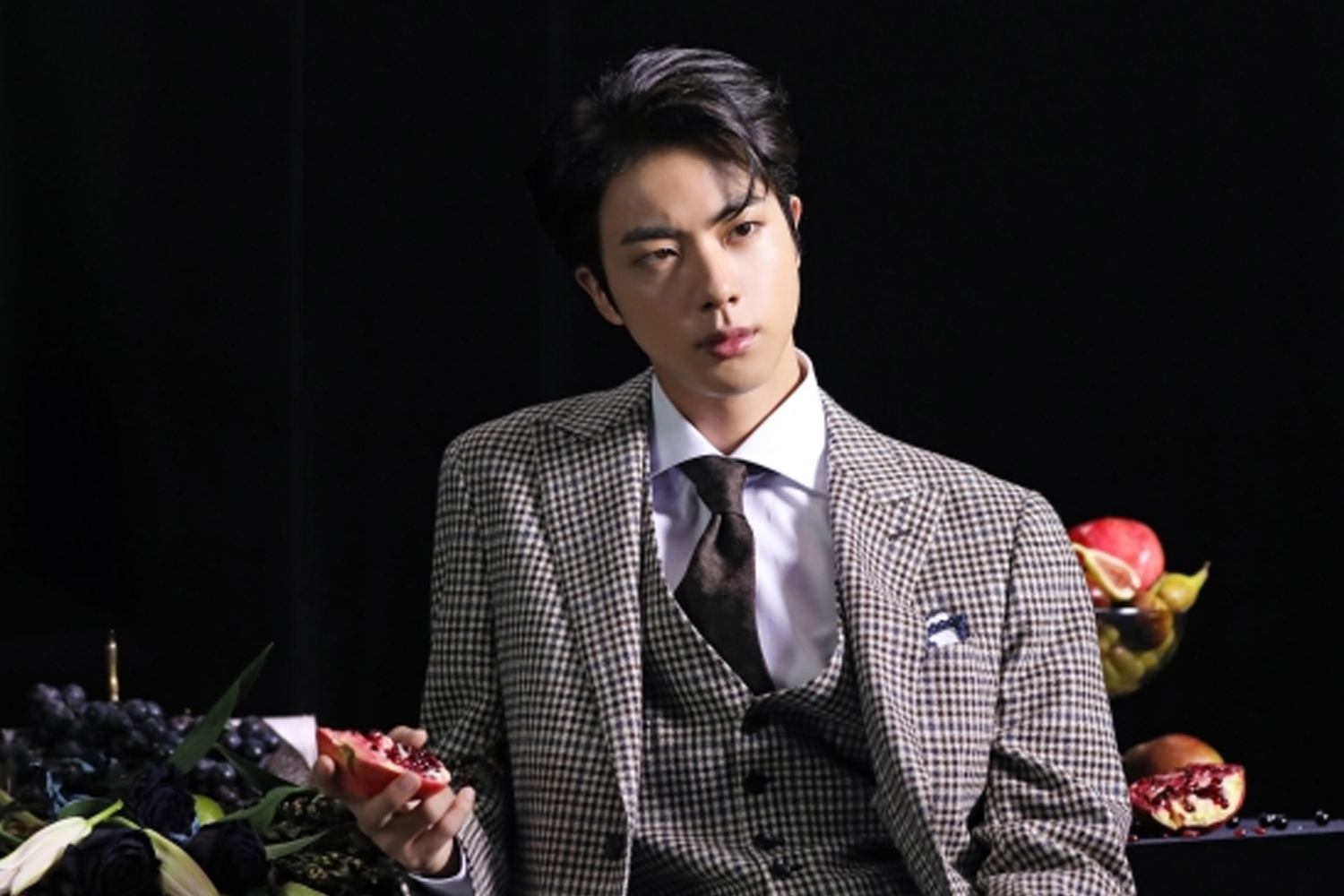 BTS의 멤버 진이 체크 패턴의 수트를 입고 있는 모습.