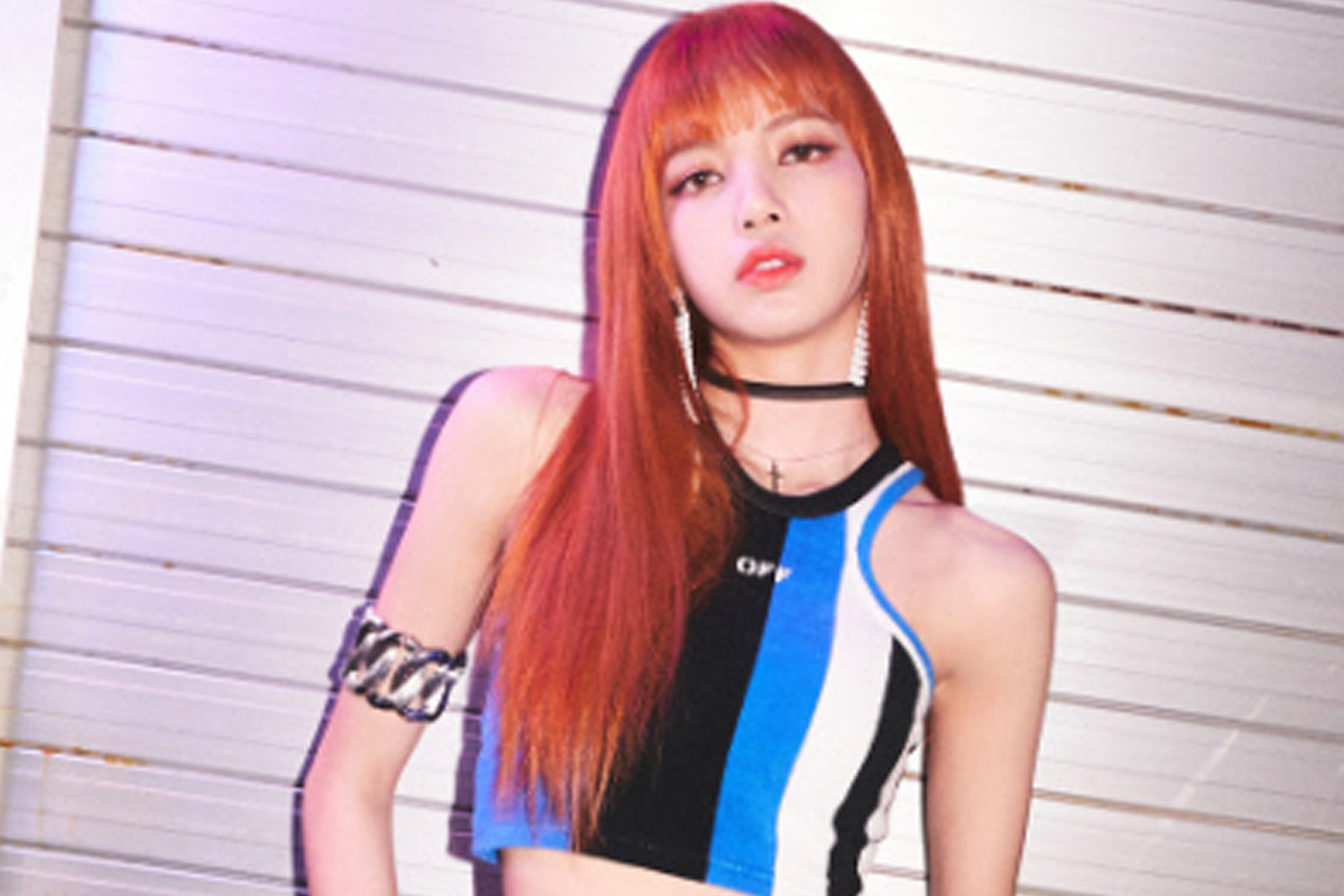 BLACKPINK의 멤버 리사가 세련된 블랙과 블루 컬러 조합의 의상을 입고 있는 모습.