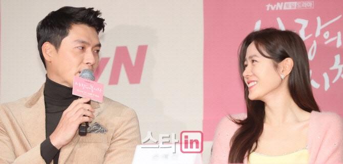 ヒョンビンとソン・イェジンがメディアイベントで対話する様子。ヒョンビンはマイクを持ち、ソン・イェジンの方を見ている。背景にはイベントのロゴが見える。