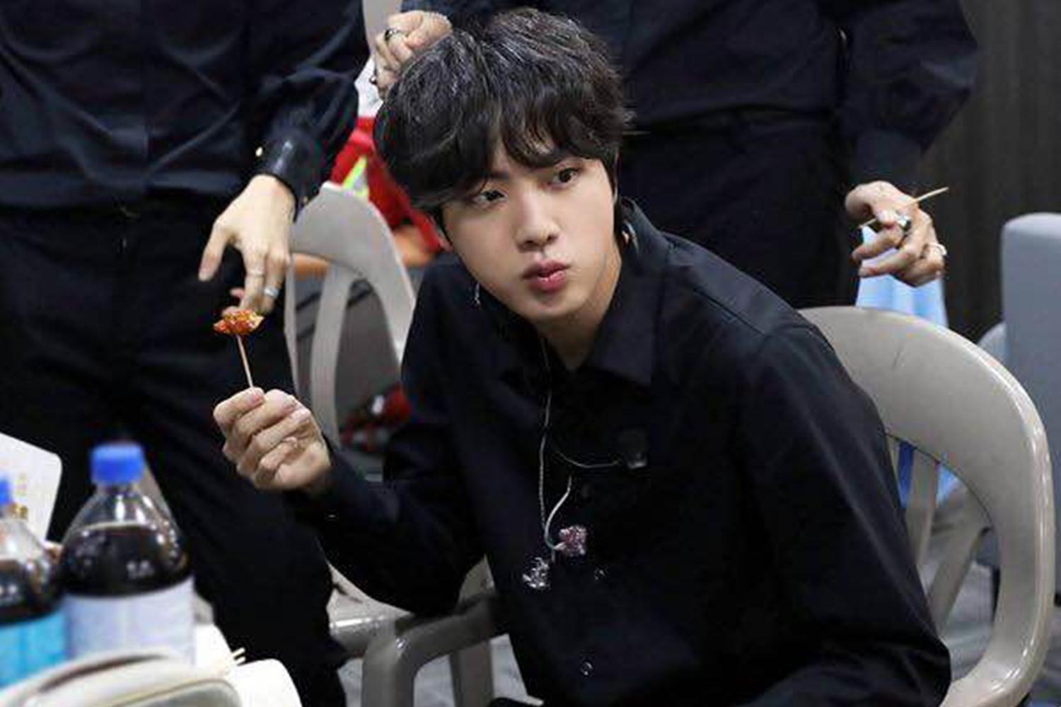 BTS Jin在建國大學電影系的學生形象，穿著襯衫，微笑著正視鏡頭。