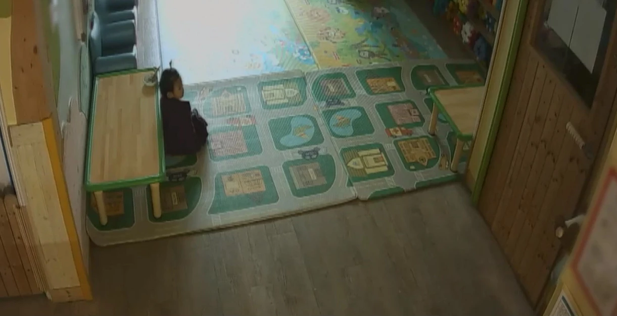 监视器画面显示郑仁在育儿所的最后一天，深刻揭露了悲剧的前兆。