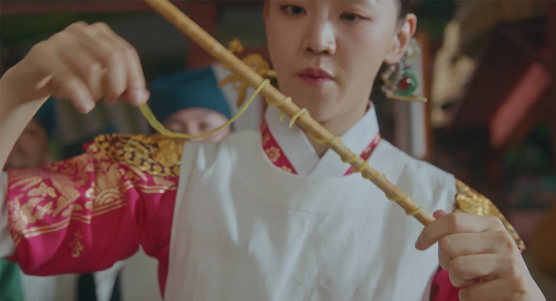 臺灣王朝大廚展示用竹筷夾起的自製麵條，象徵拉麵製作的關鍵步驟。