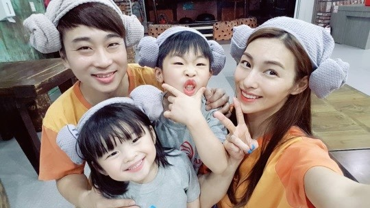 在韩国汗蒸幕内的一家人，穿着传统桑拿服装，头上戴着羊角毛巾。