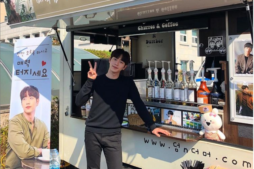 チュロスとコーヒーを提供するフードトラックの前に立っている男性。