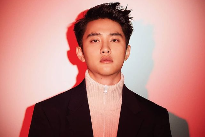 赤い背景で撮影されたタートルネックを着た男性。