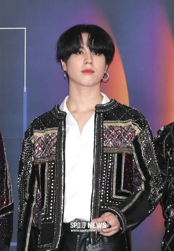 GOT7のメンバー、ユギョムがキラキラした衣装を着ている画像。彼はJYPエンターテイメントを離れ、AOMGと契約予定。SPOTV NEWSのロゴが画像下部にあります。